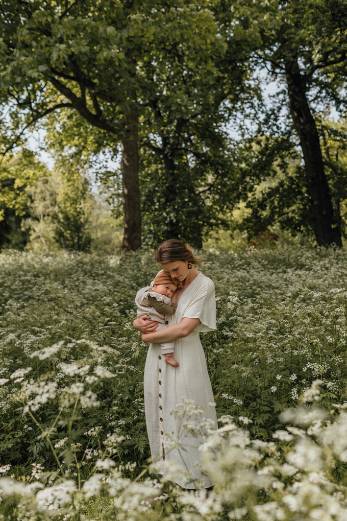 Mother holds daughter in meadow of flowers at Christchurch Botanic Gardens